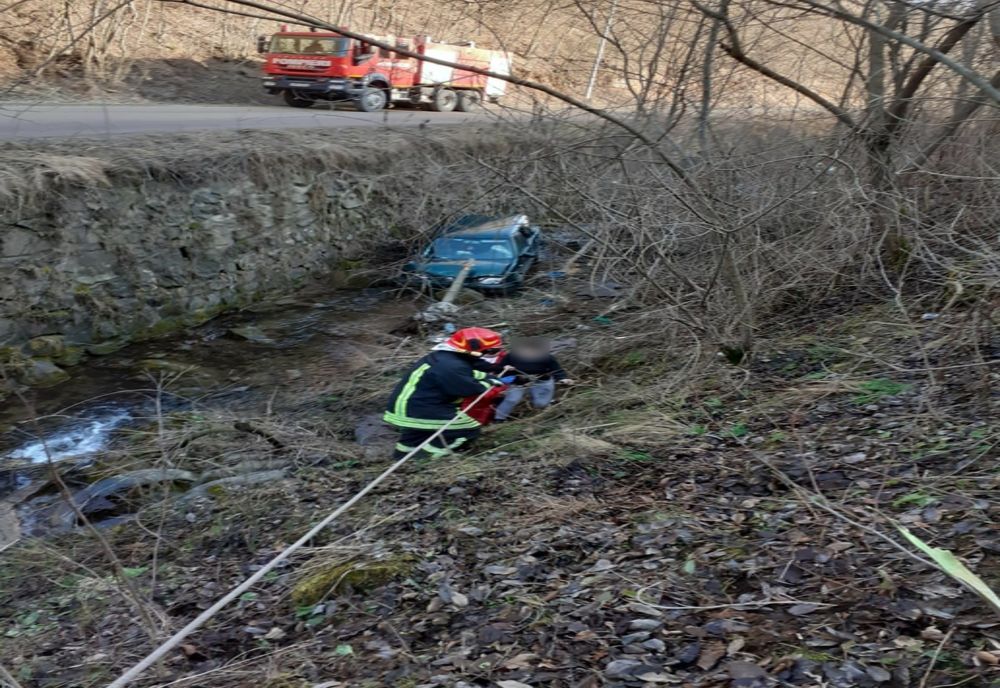 FOTO | Intervenție pentru salvarea a doi adulți și a unui copil care au căzut cu mașina în gol